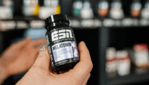 a hand holding a bottle of vitamins from esn.